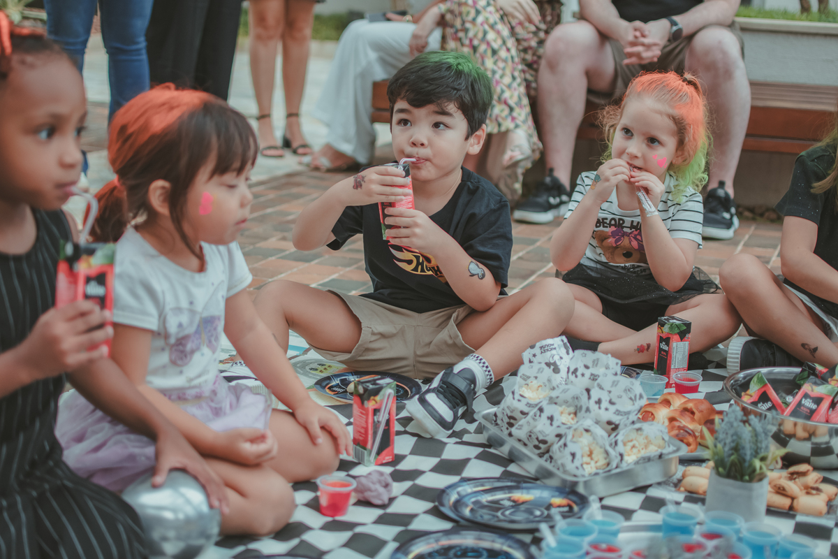 Crianças durante um piquenique em uam festa de aniversário infantil.