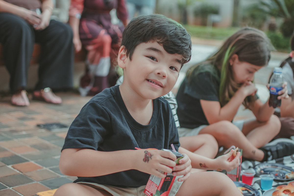 Crianças durante um piquenique em uam festa de aniversário infantil.