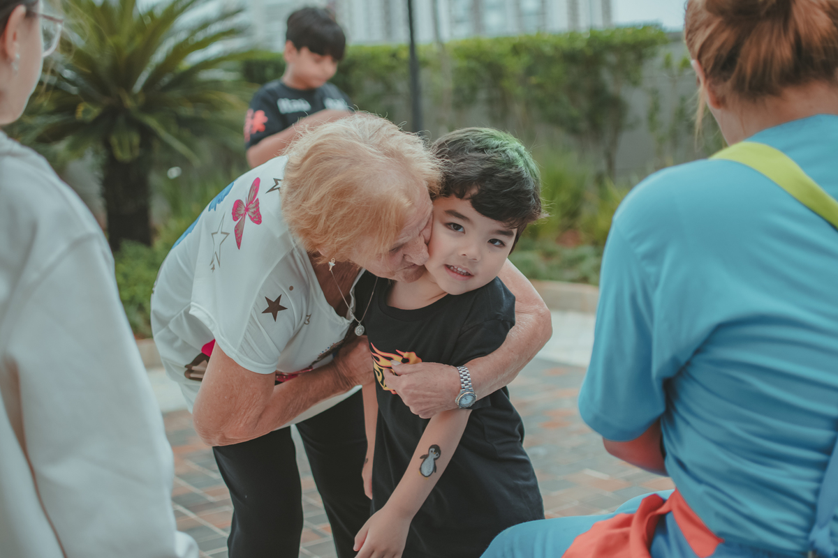 Um avó abrançando o neto, durante sua festa de aniversário.