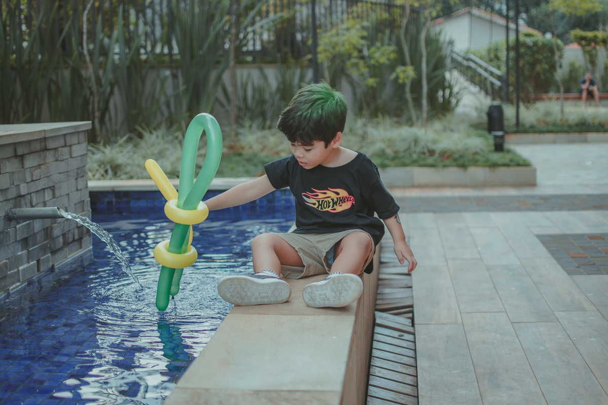 Um menino brincando com escultura de bexiga, durante sua festa de aniversário.