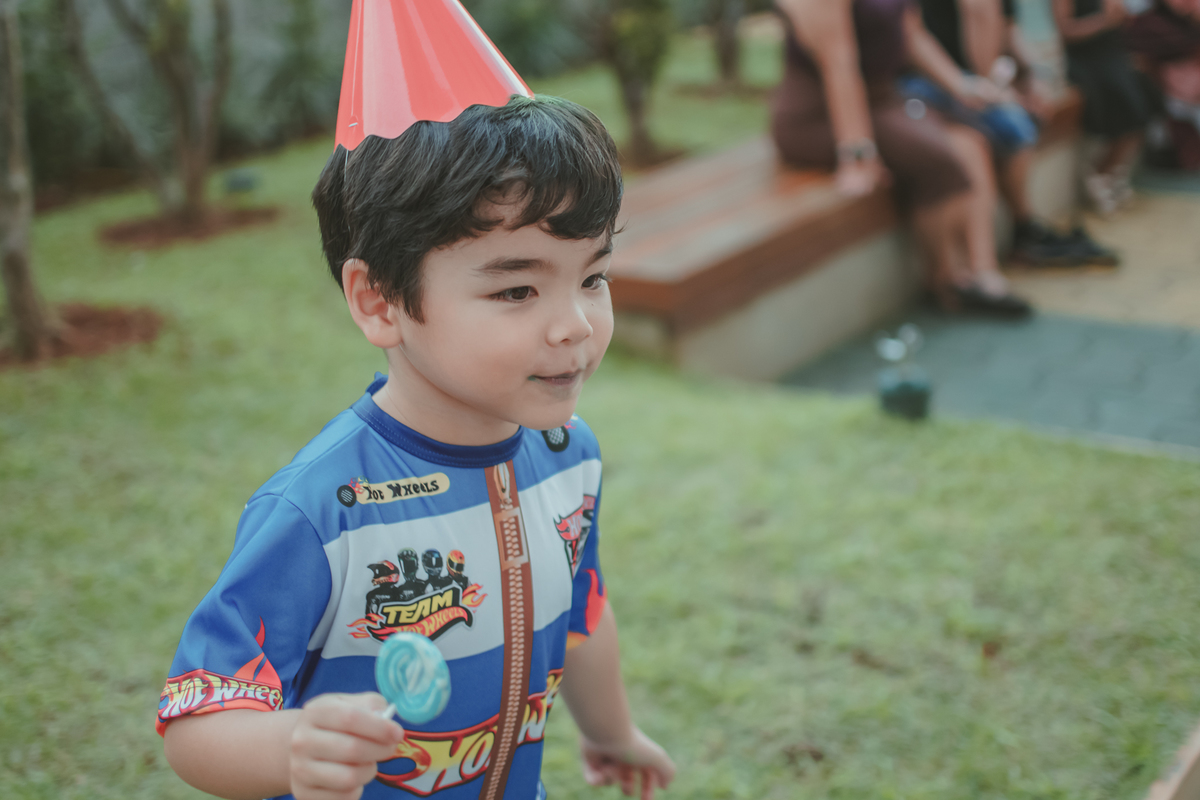 Um menino vestido de piloto de corrida da hot Wheels, durante sua festa de aniversário de 4 anos.