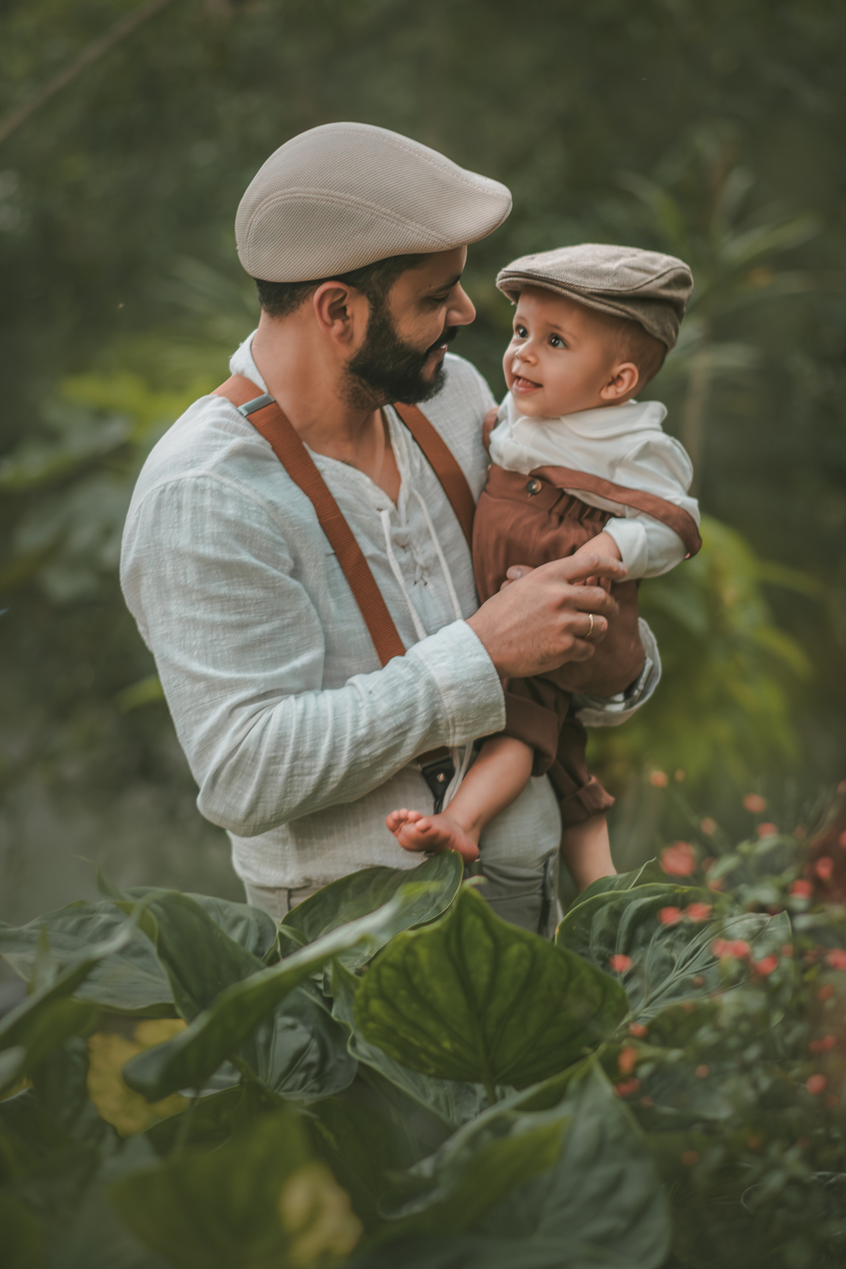 um pai com seu bebê ambos vestidos de camponeses, durante um ensaio fotográfico de 1 ano na natureza.