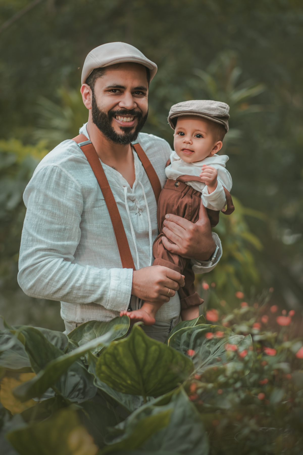 Um pai com seu bebê ambos vestidos de camponeses, durante um ensaio fotográfico de 1 ano na natureza.