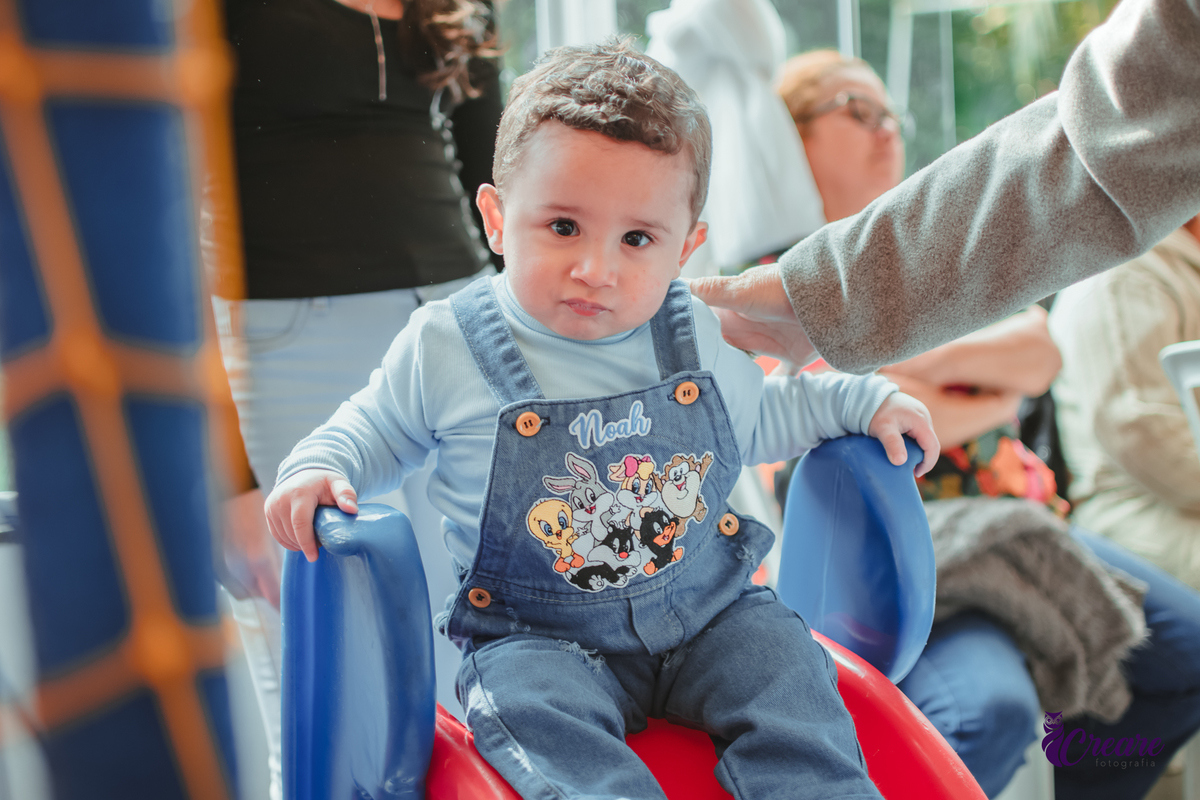 Um bebê de 1 ano brincando em um escorrega durante sua festa de aniversário.