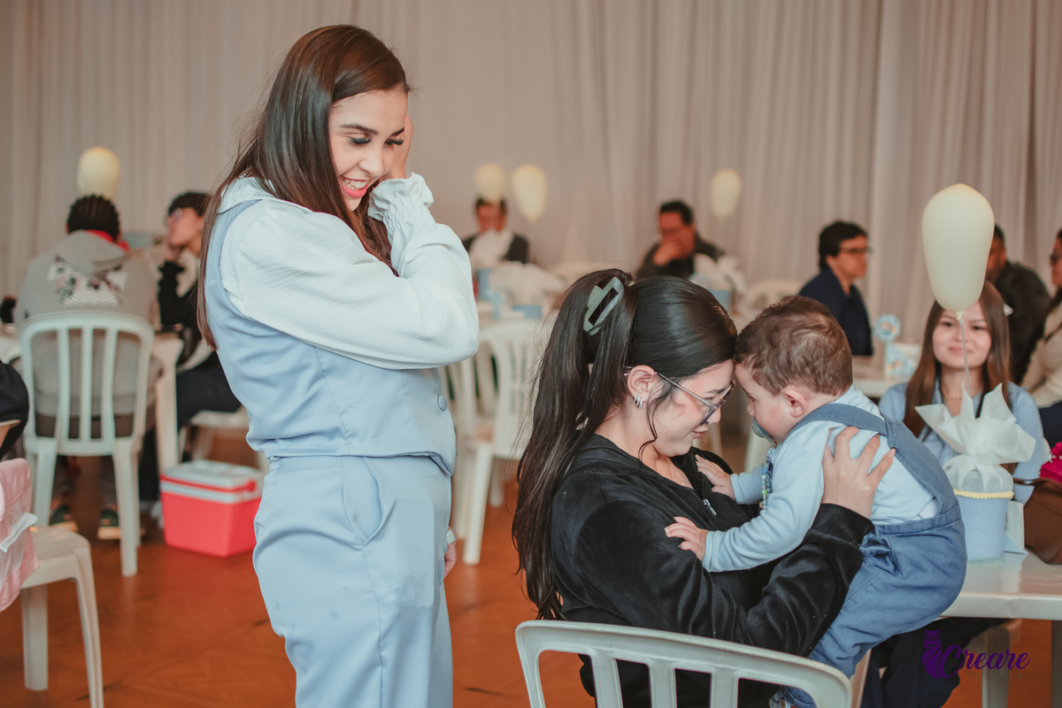 Um bebê brincando com convidados da sua festa de aniversário de 1 ano.