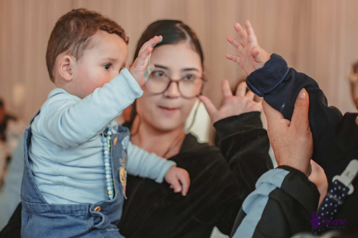 Um bebê brincando com convidados da sua festa de aniversário de 1 ano.