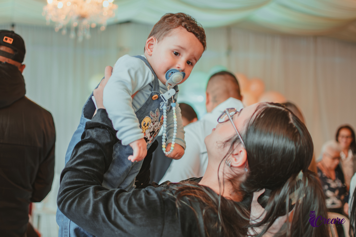 Um bebê brincando com convidados da sua festa de aniversário de 1 ano.