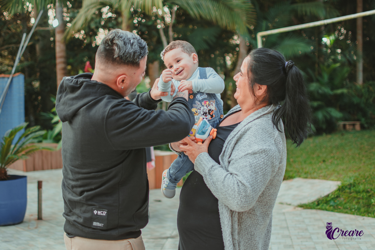 Um bebê brincando com convidados da sua festa de aniversário de 1 ano.