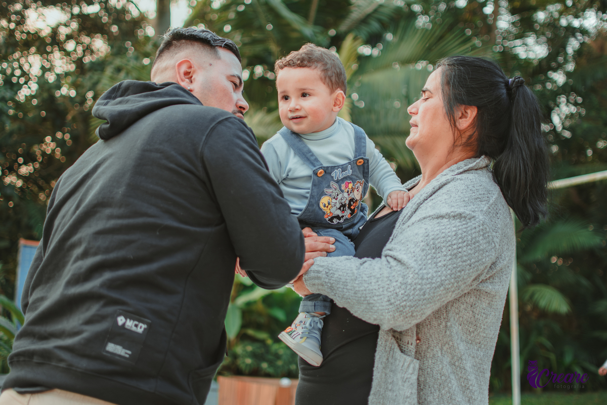 Um bebê brincando com convidados da sua festa de aniversário de 1 ano.