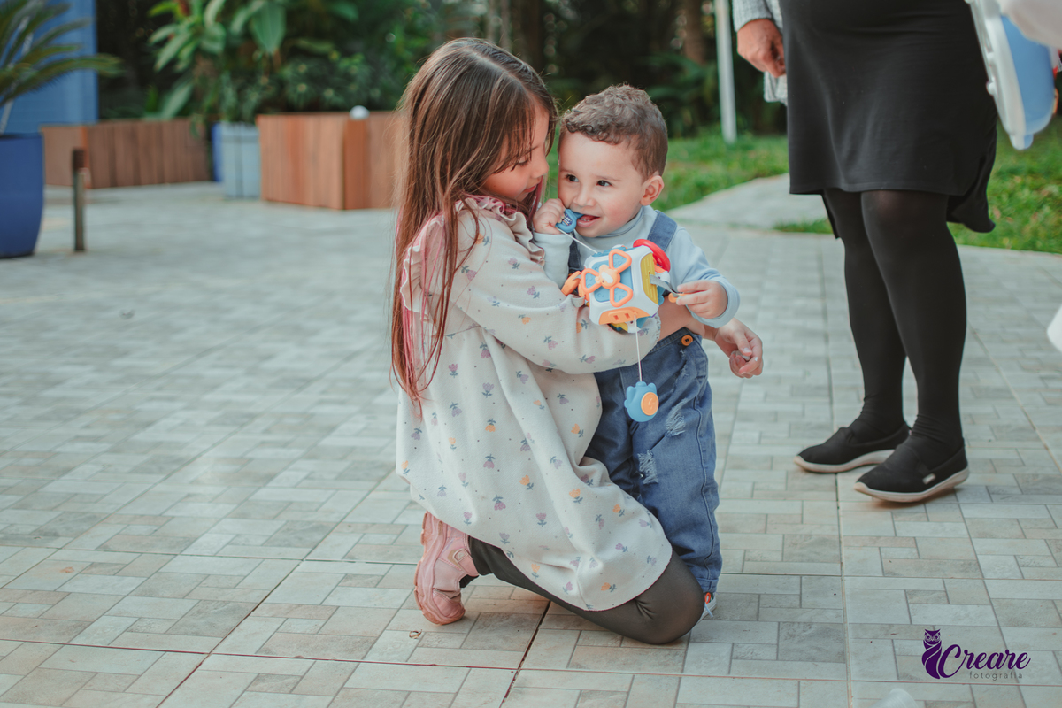 Um bebê brincando com convidados da sua festa de aniversário de 1 ano.