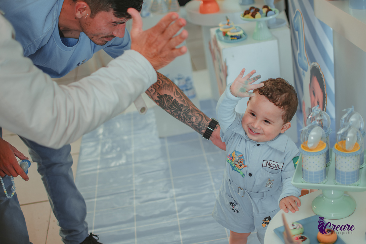 Um bebê brincando com convidados da sua festa de aniversário de 1 ano.