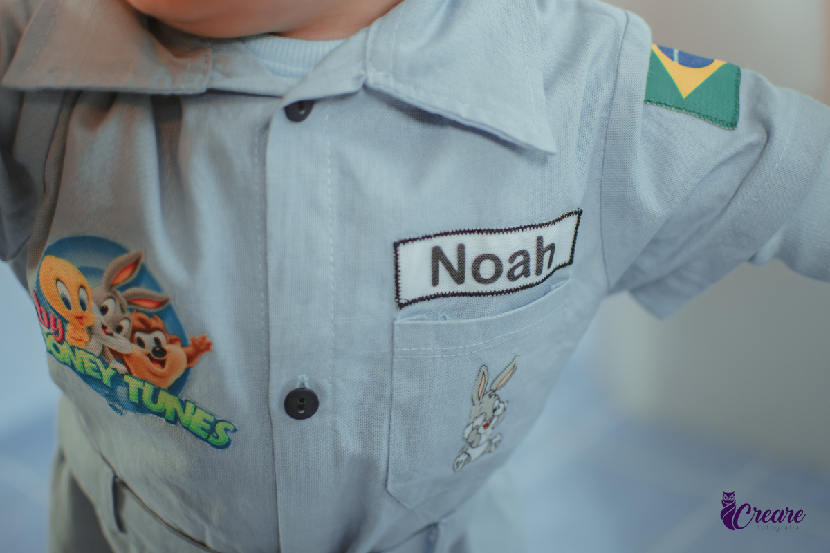Detalhes da roupa de uma bebê escrito seu nome Noah e com personagens do desenho Baby Looney tunes.