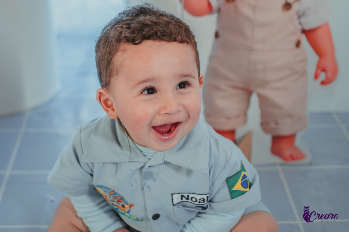 Um bebê, vestido com roupas personalizadas do desenho Baby Looney tunes e brincando em sua festa de aniversário de 1 ano.