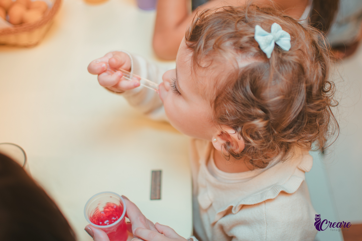 Uma criança comendo gelatinha, na hora do lanchinho durante seu aniversário de 2 anos no buffet Happy House.