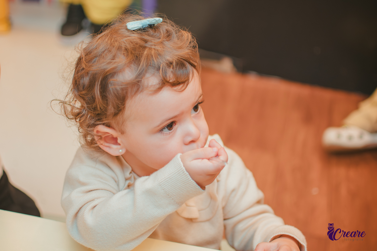 Uma criança comendo gelatinha, na hora do lanchinho durante seu aniversário de 2 anos no buffet Happy House.