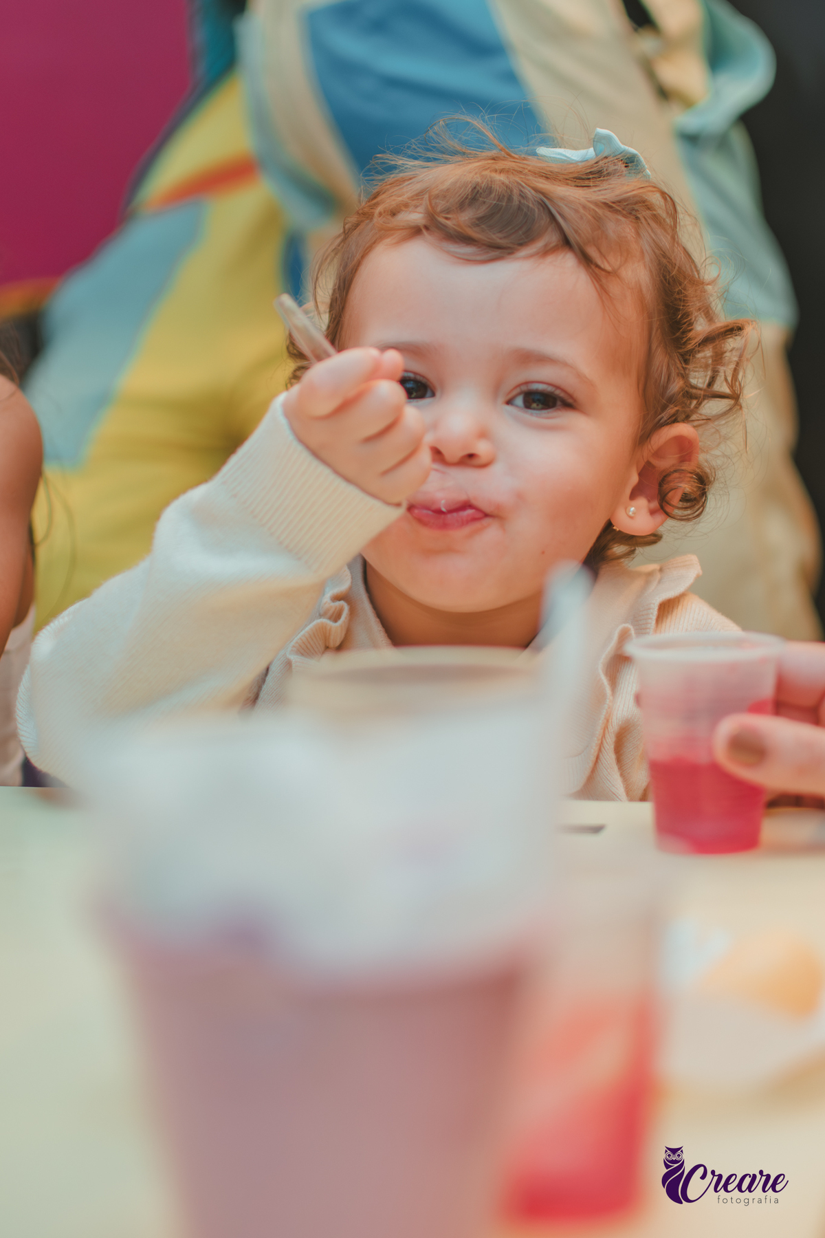 Uma criança comendo gelatinha, na hora do lanchinho durante seu aniversário de 2 anos no buffet Happy House.