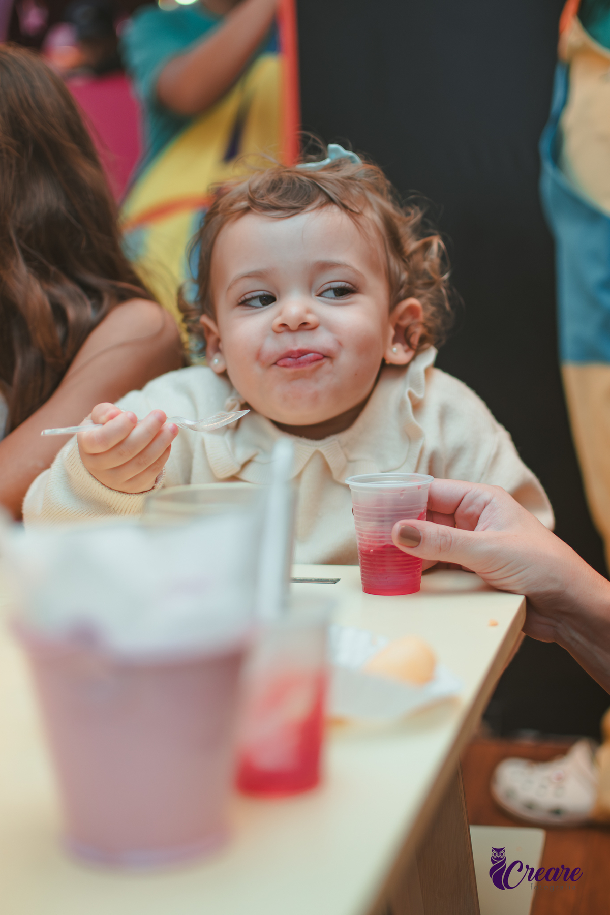 Uma criança comendo gelatinha, na hora do lanchinho durante seu aniversário de 2 anos no buffet Happy House.