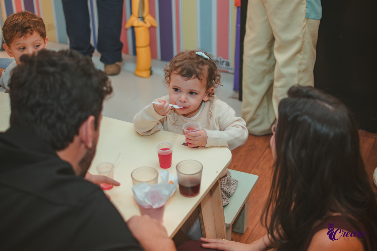 Uma criança comendo gelatinha, na hora do lanchinho durante seu aniversário de 2 anos no buffet Happy House.