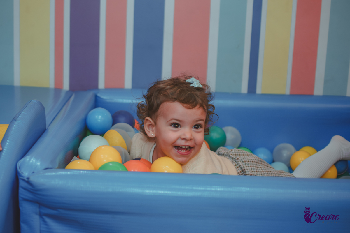 Uma criança brincando na piscina de bolinhas durante sua festa de aniversário de 2 anos no Buffet Happy House em Santo André