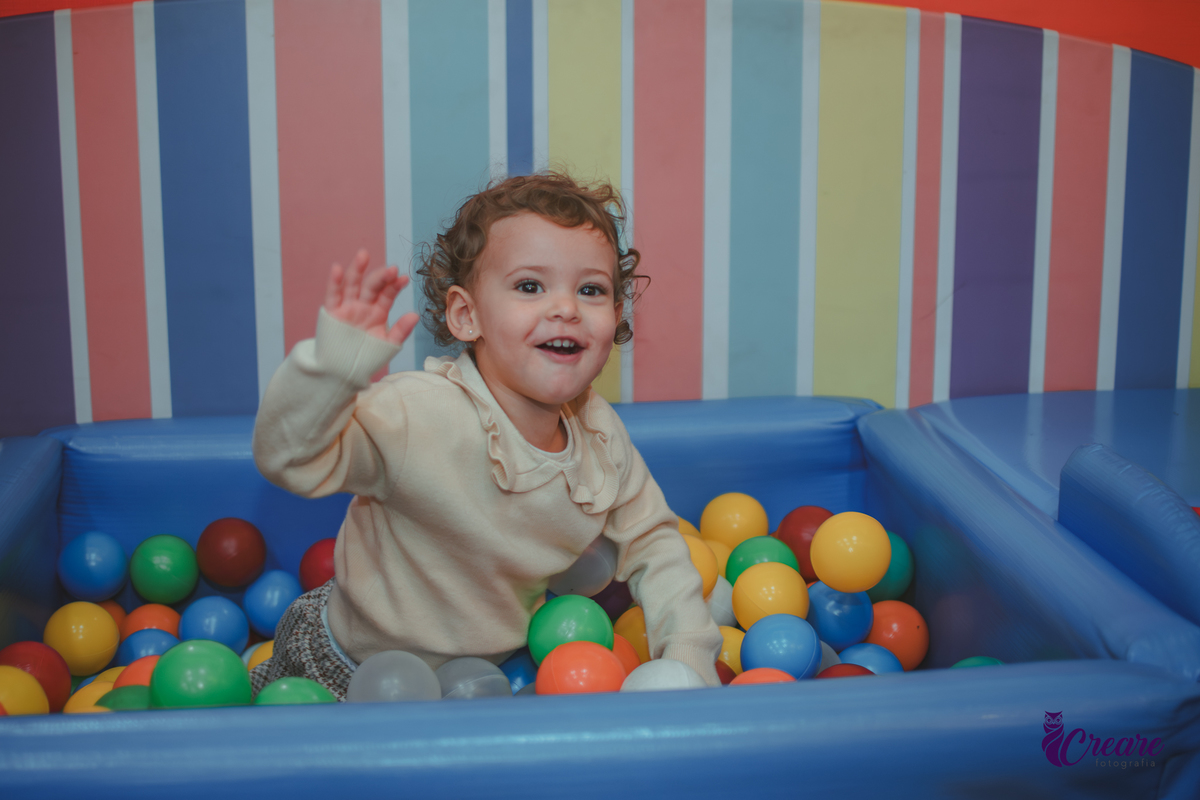 Uma criança brincando na piscina de bolinhas durante sua festa de aniversário de 2 anos no Buffet Happy House em Santo André
