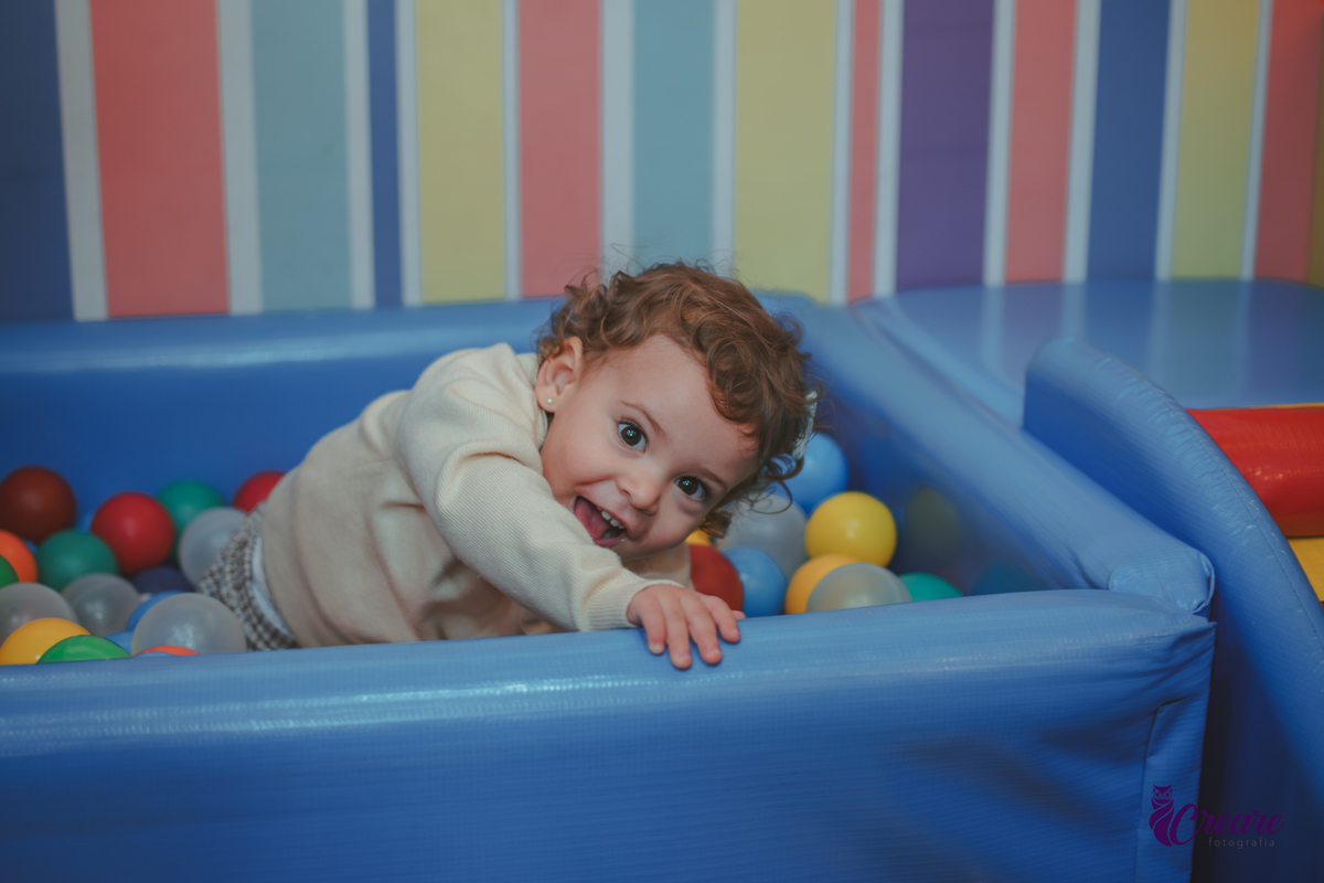 Uma criança brincando na piscina de bolinhas durante sua festa de aniversário de 2 anos no Buffet Happy House em Santo André