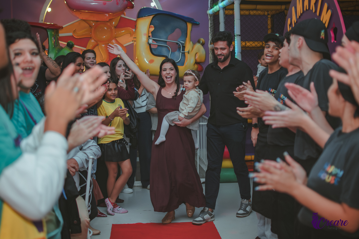 Uma familia caminhando em um tapete vermelho para cantar parabéns, durante o aniversário de 1 ano no Buffet Happy House em Santo André.
