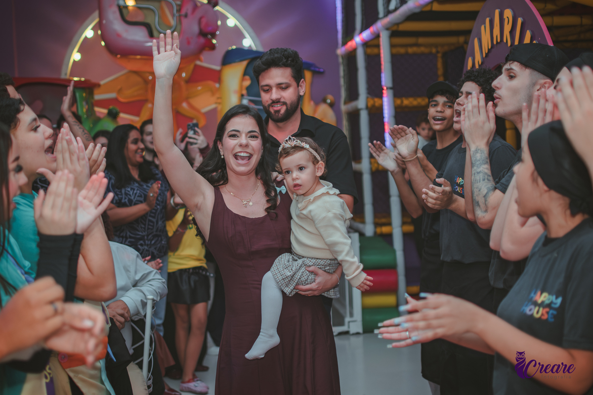 Uma familia caminhando em um tapete vermelho para cantar parabéns, durante o aniversário de 1 ano no Buffet Happy House em Santo André.