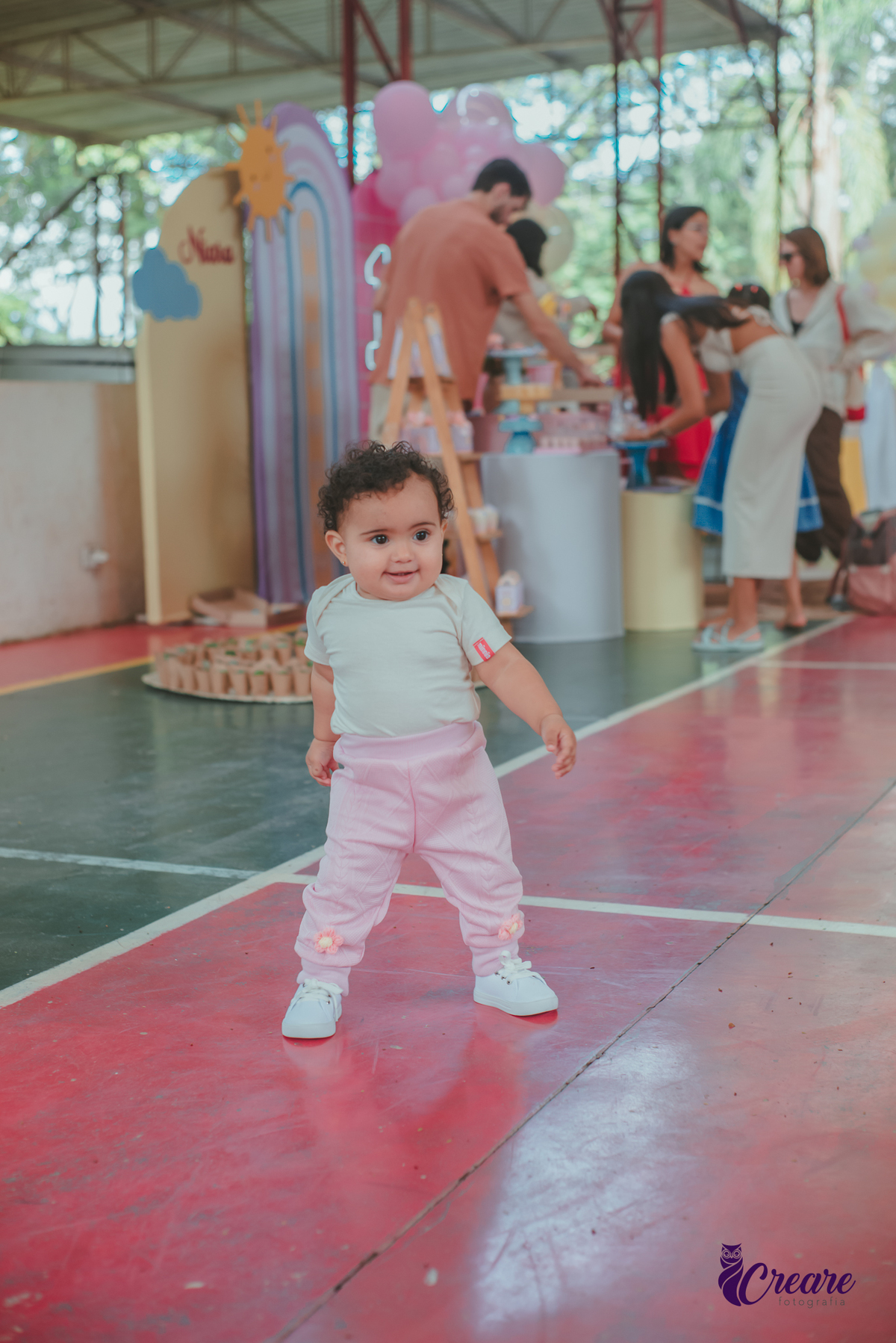 Bebê de um ano sorrindo, durante sua festa de aniversário.