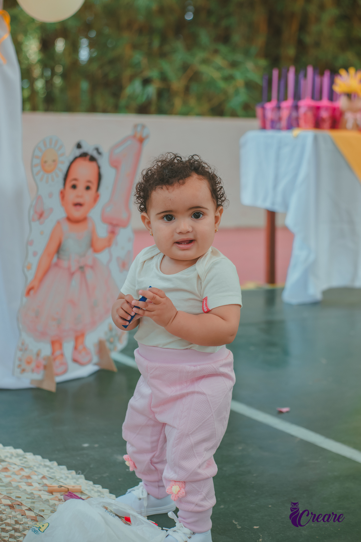 Bebê de um ano sorrindo, durante sua festa de aniversário.