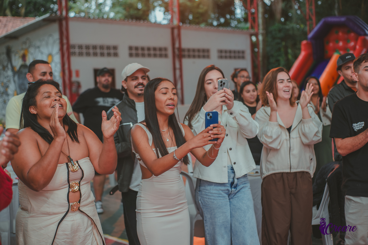 Convidados de festa de aniversário de 1 ano cantando parabéns.