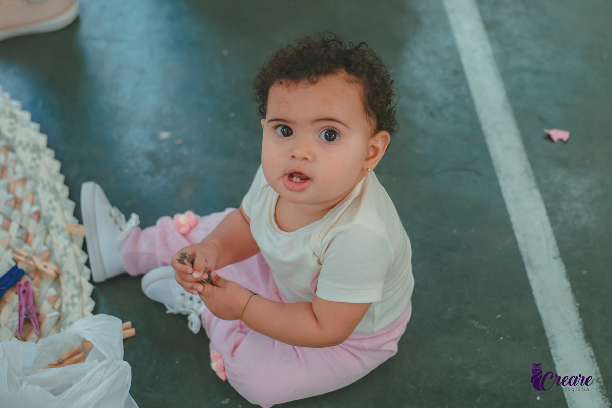 Bebê de um ano sorrindo, durante sua festa de aniversário.