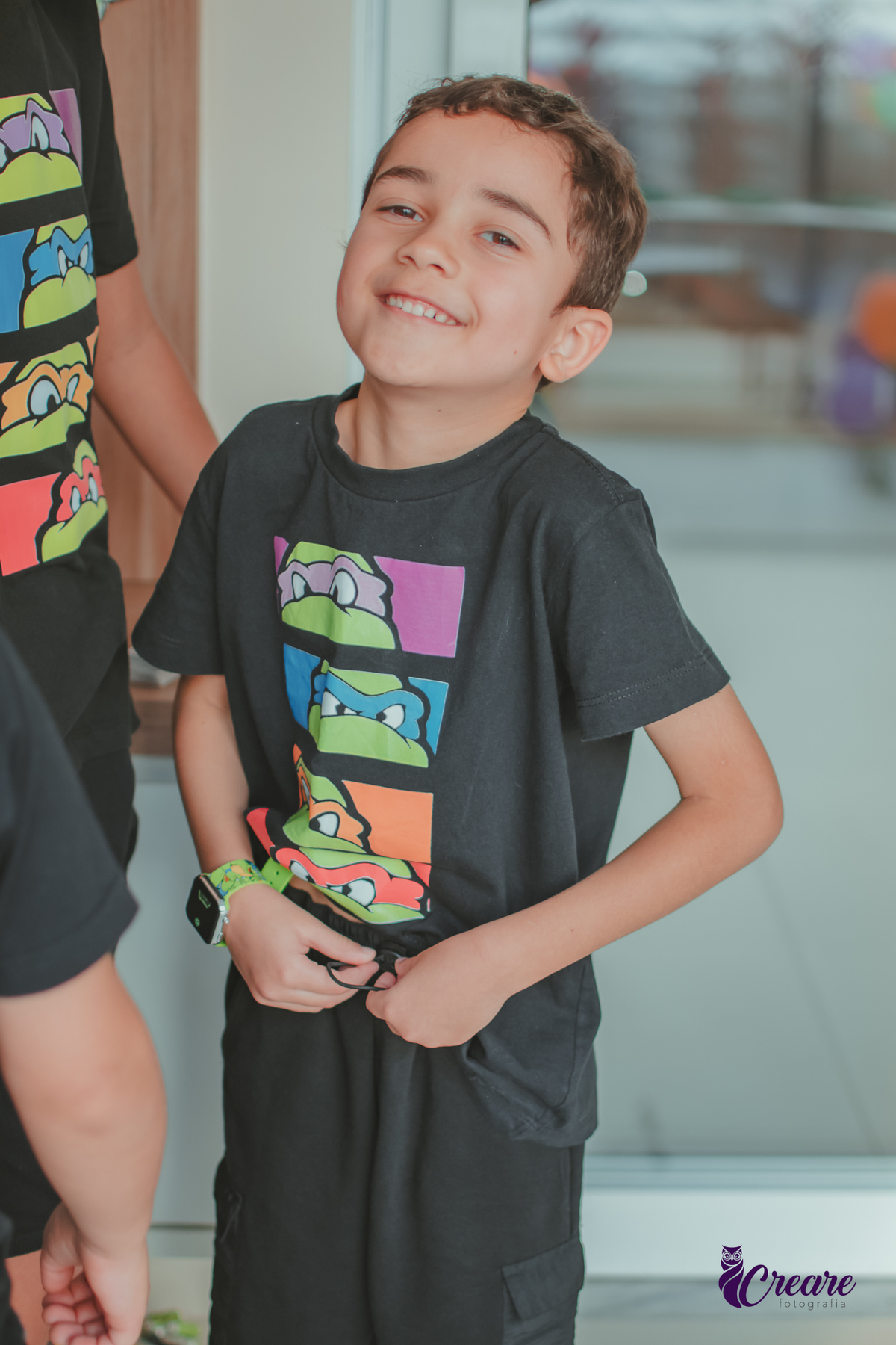 Uma criança sorrindo durante sua festa de aniversário em casa.