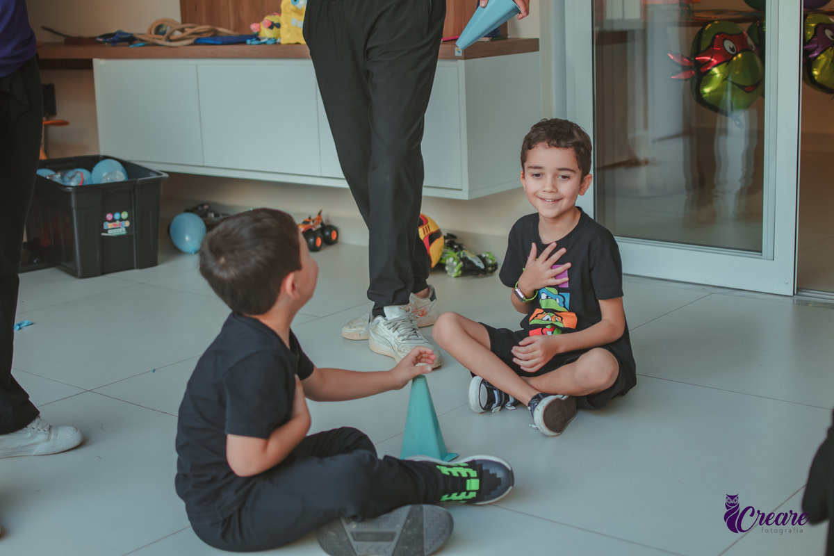 Crianças brincando juntas durante festa de aniversário em casa.