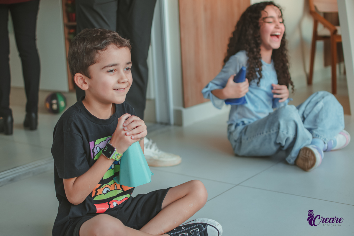 Crianças brincando juntas durante festa de aniversário em casa.