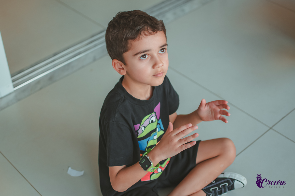Um menino batendo palma durante uma brincadeira em seu aniversário.