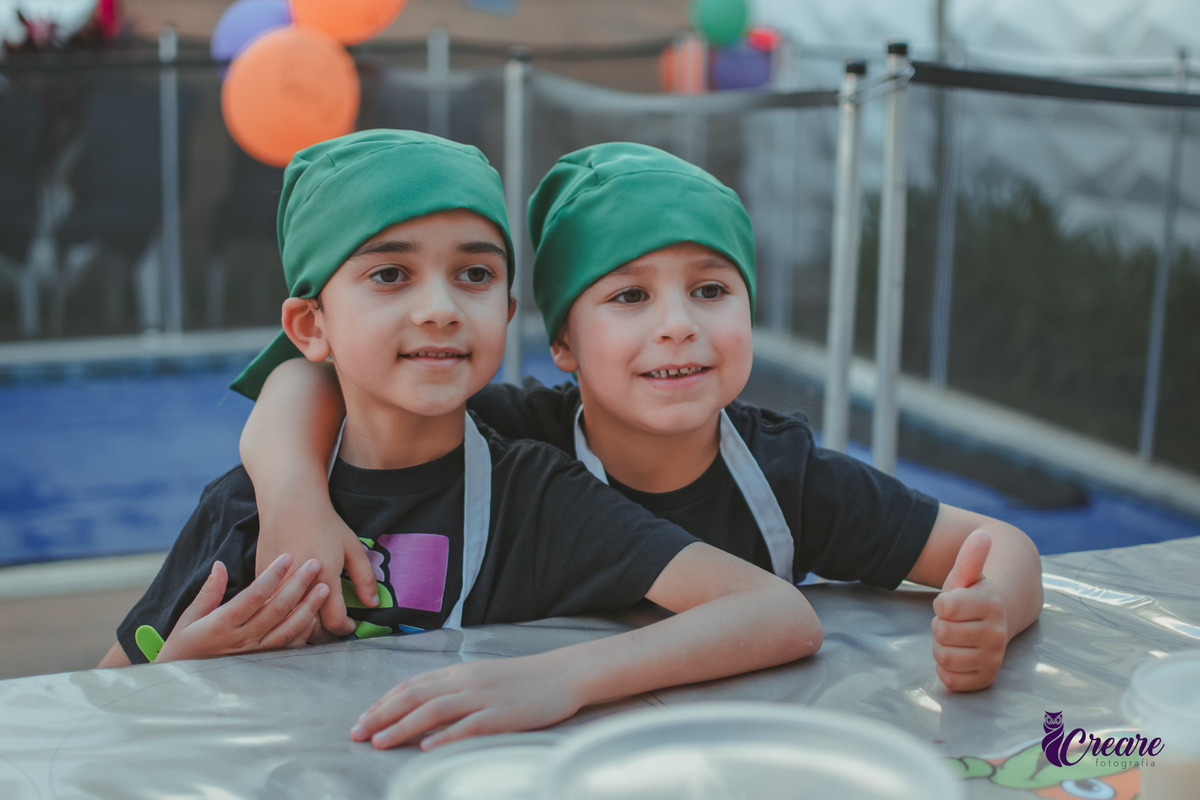 Duas crianças posando para foto durante festa de aniversário.