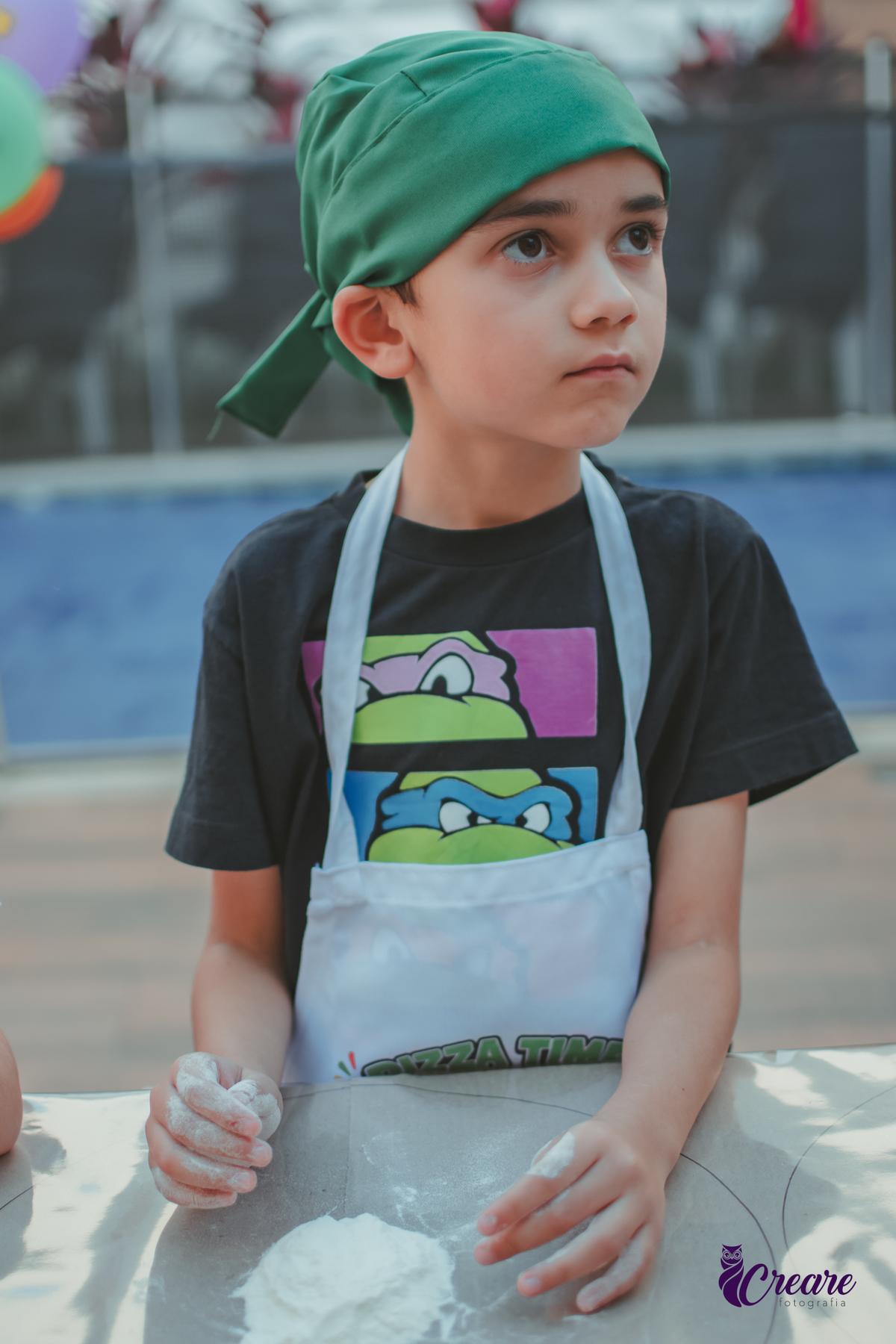 Crianças preparando pizza durante brincadeira de festa de aniversário infantil em casa.