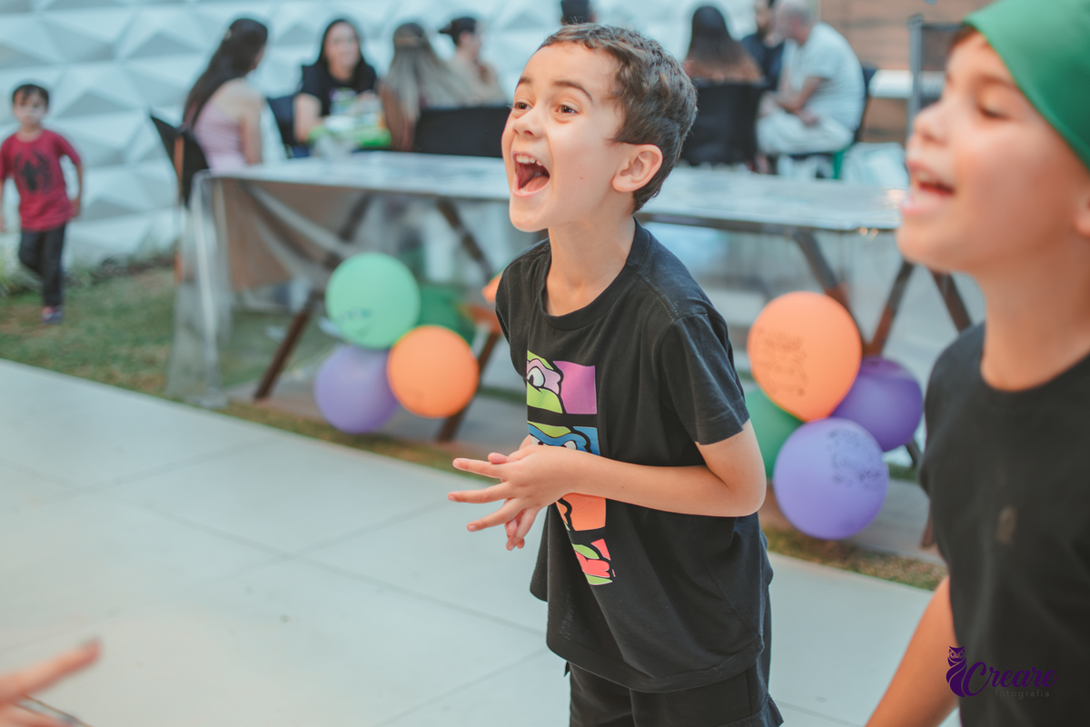 Um menino sorrindo durante brincadeira de cabra cega em seu aniversário em casa.