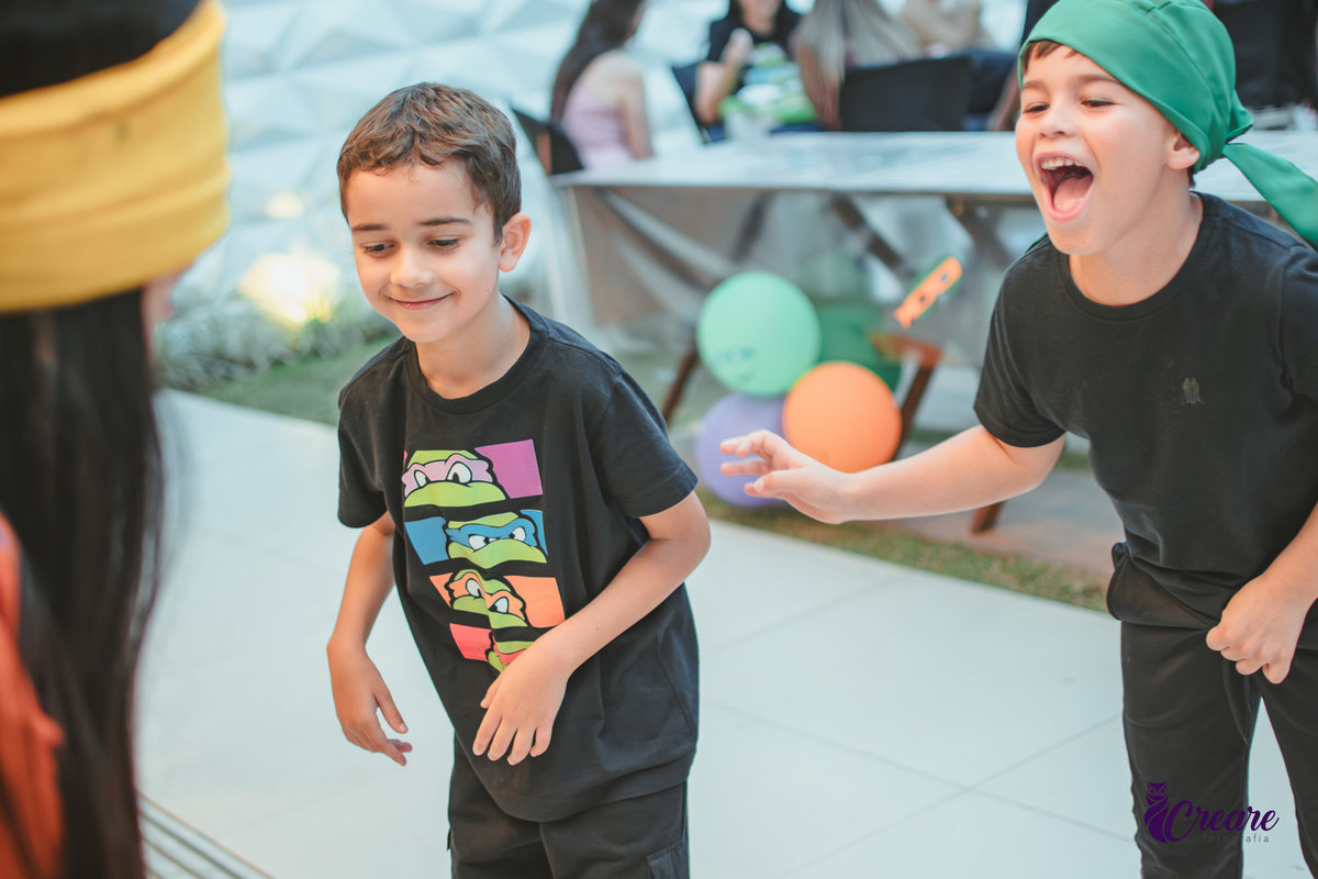Um menino sorrindo durante brincadeira de cabra cega em seu aniversário em casa.