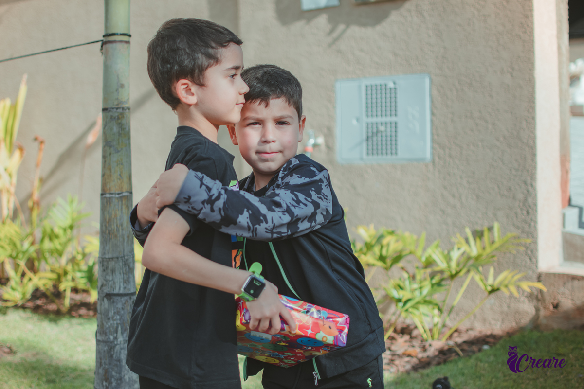 duas crianças se abraçando durante uma festa de aniversário.