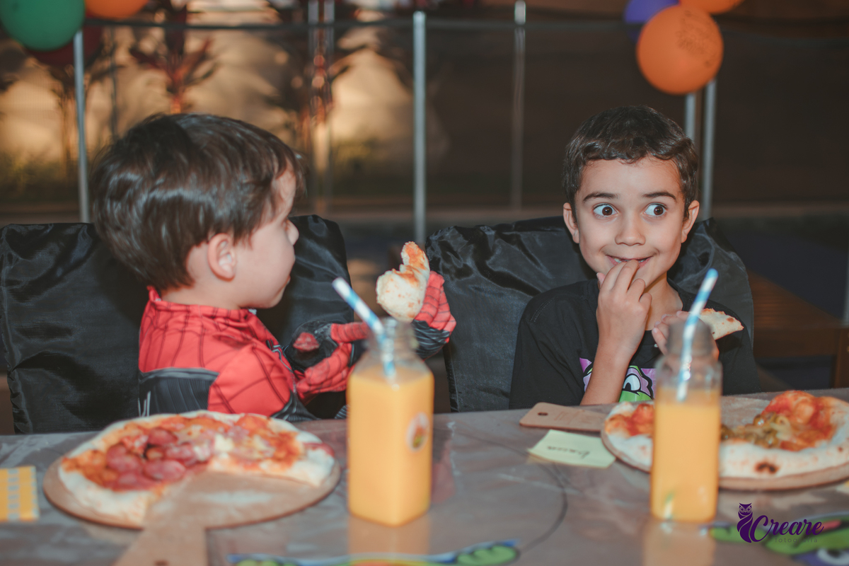 várias criança comendo a pizza que produziram na oficina de pizza, durante sua festa de aniversário em casa.