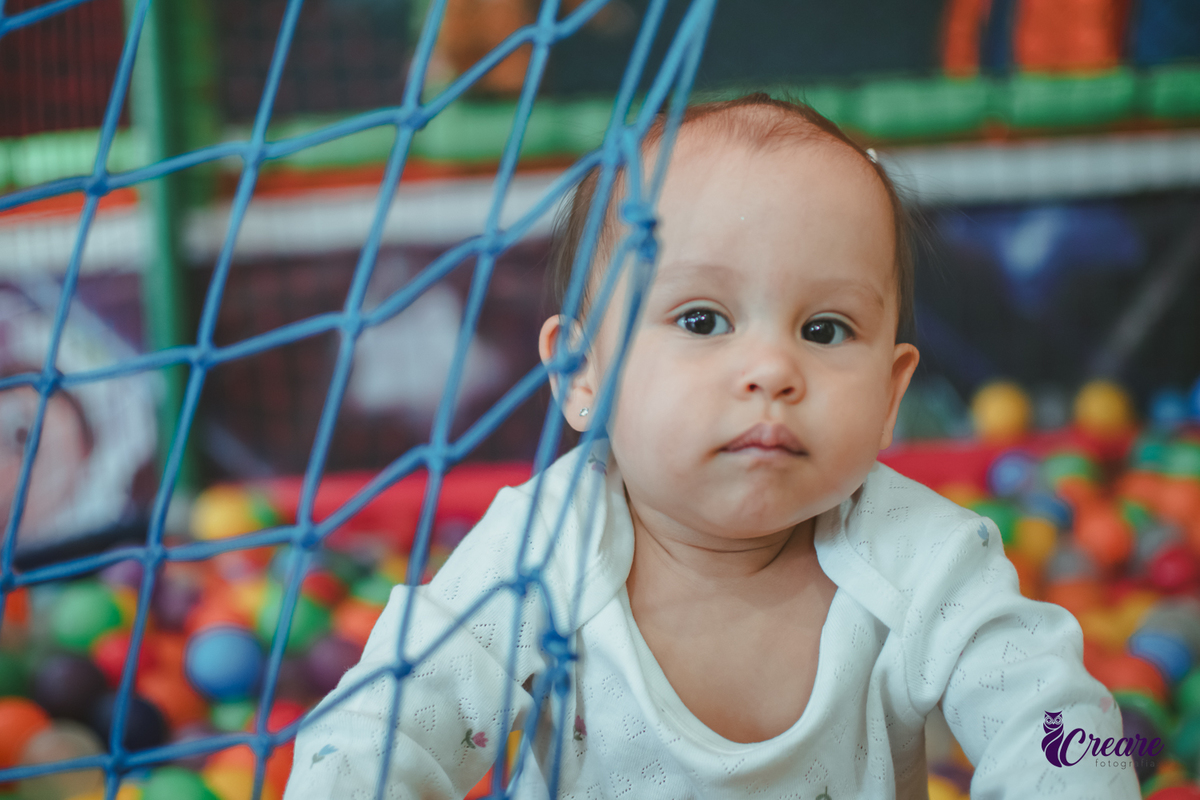 Uma bebê brincando nas piscina de bolinhas durante sua festa de aniversário de 1 ano.