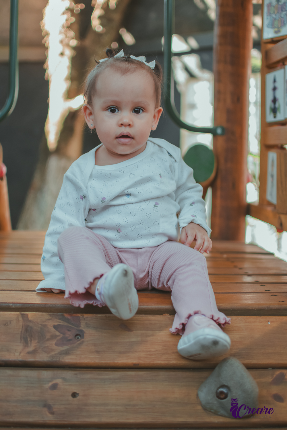 Uma criança sentada em um brinquedo de madeira durante sua festa de aniversário.