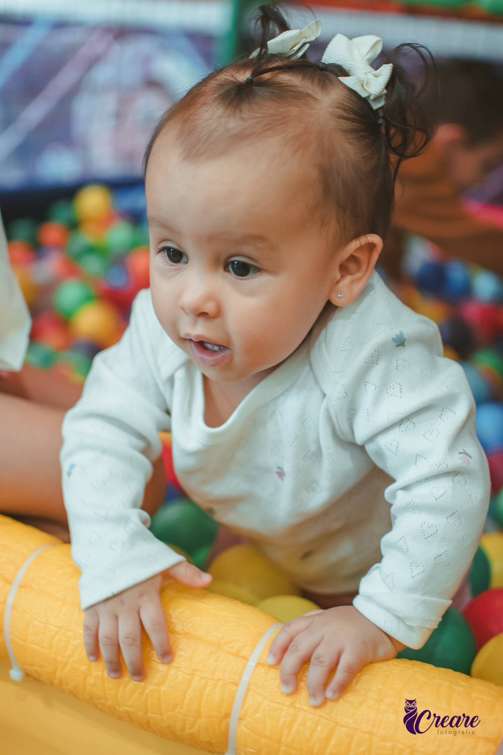 Uma bebê brincando nas piscina de bolinhas durante sua festa de aniversário de 1 ano.