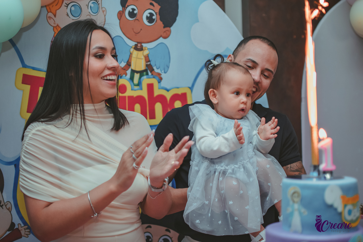 Uma família cantando parabéns, durante festa de aniversário de 1 ano.