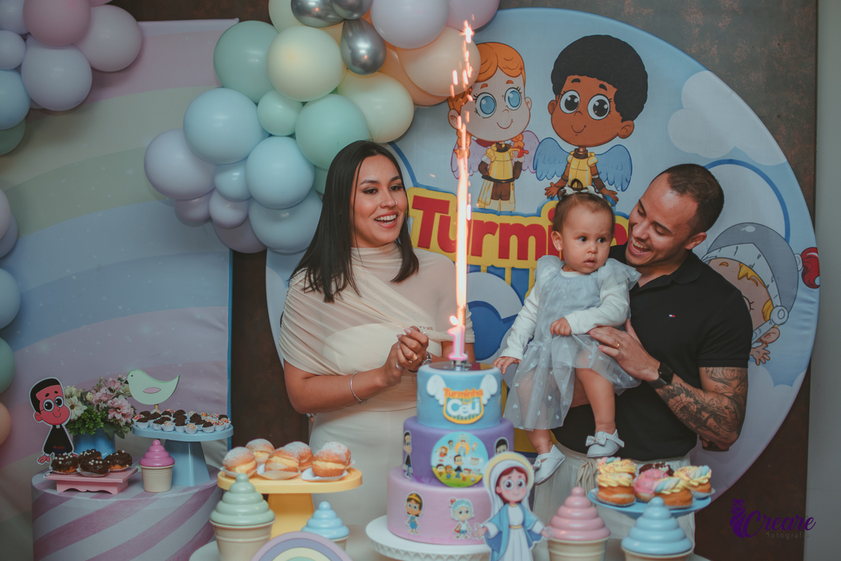 Uma família cantando parabéns, durante festa de aniversário de 1 ano.