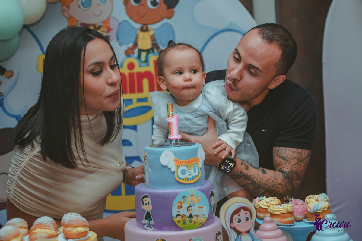 Uma família cantando parabéns, durante festa de aniversário de 1 ano.