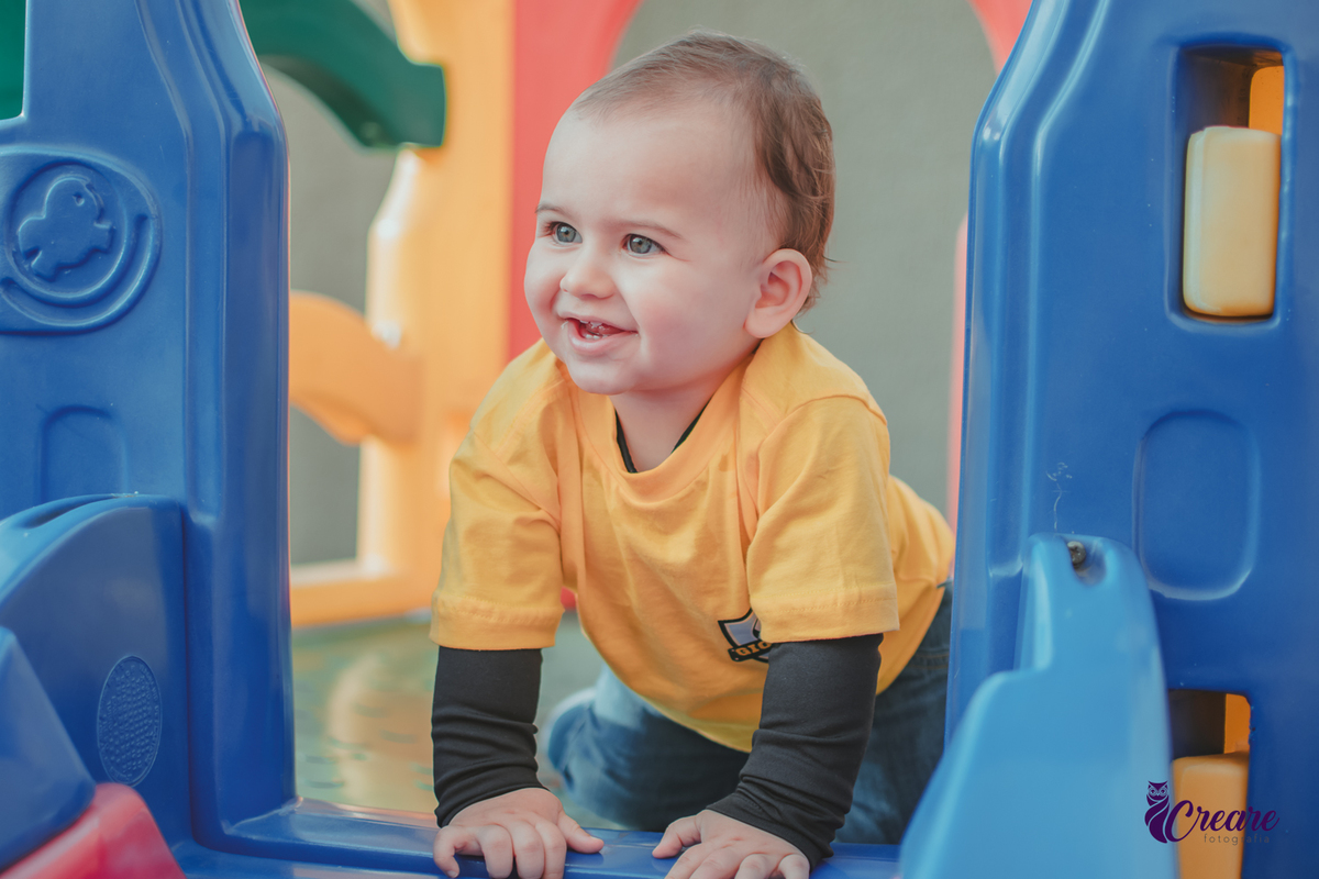 Um bebê sorrindo e brincando durante seu aniversário de 1 ano.