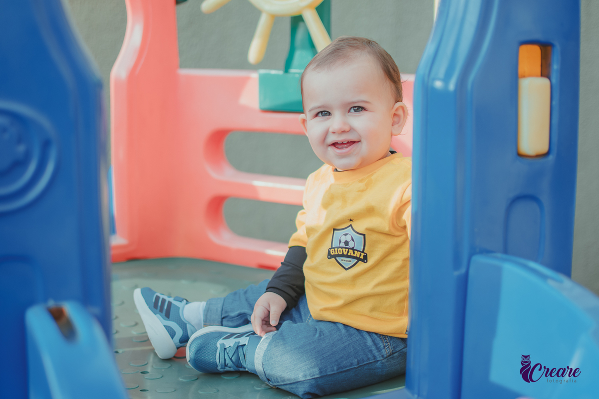Um bebê sorrindo e brincando durante seu aniversário de 1 ano.