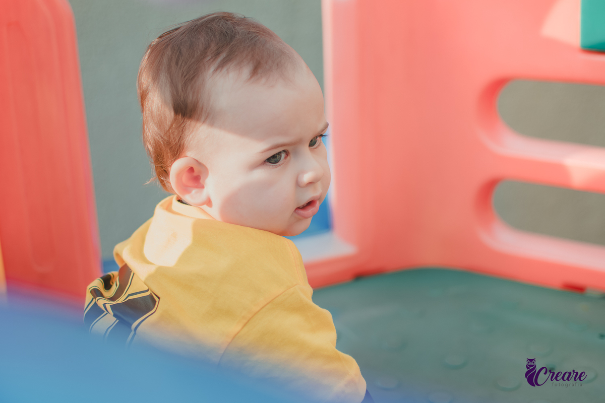 Um bebê sorrindo e brincando durante seu aniversário de 1 ano.